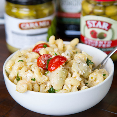 An easy pasta salad full of olives, artichoke hearts, tomatoes, parsley, and feta cheese. Topped with a light vinaigrette dressing for a cool and delicious dish.  #STARFineFoods